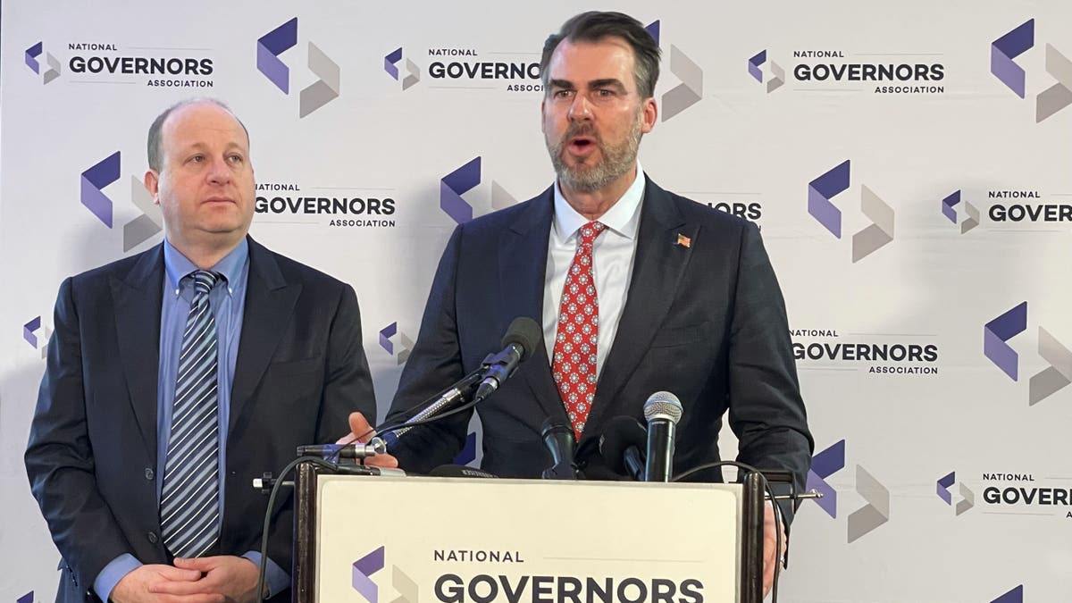 OK Gov. Kevin Stitt speaks as Gov. Jared Polis listens at the NGA in Washington