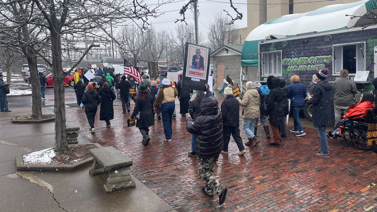 DOGE protesters march down the street.