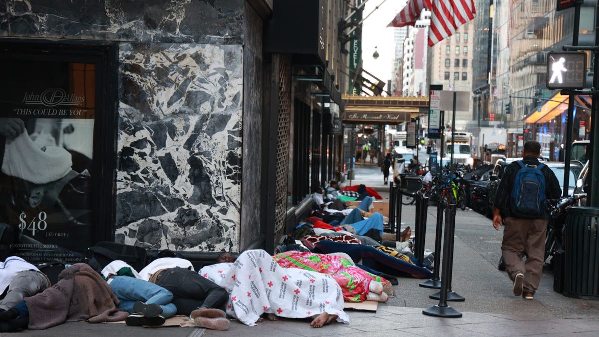 Migrants sleep on the street outside the Roosevelt Hotel