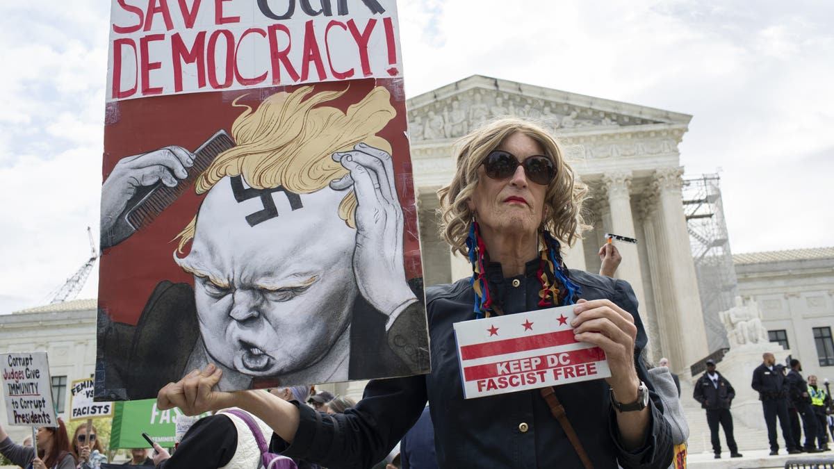 An activist holding a sign with Save Our Democracy written on it stands outside the US Supreme Court, as the court prepares to hear arguments on the immunity of former President Donald Trump in Washington, DC. (Photo by Probal Rashid/LightRocket via Getty Images)