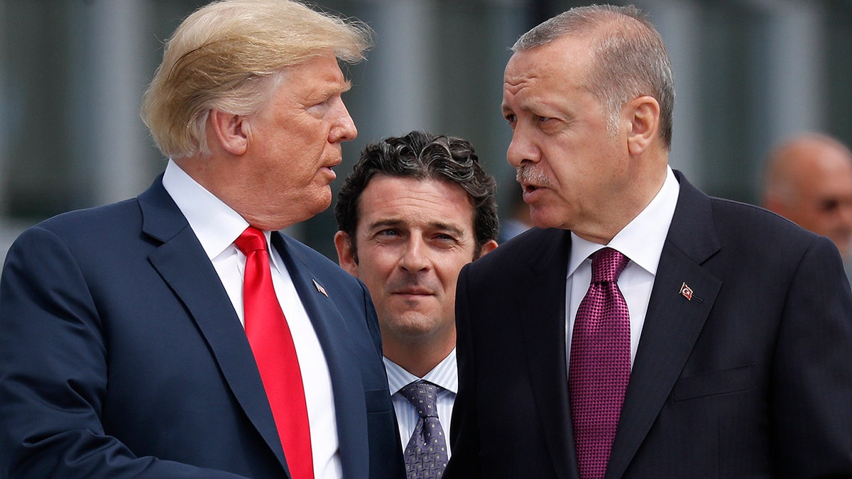 President Donald Trump, left, talks with Turkey's President Recep Tayyip Erdogan, as they arrive together for a family photo at a summit of heads of state and government at NATO headquarters in Brussels.