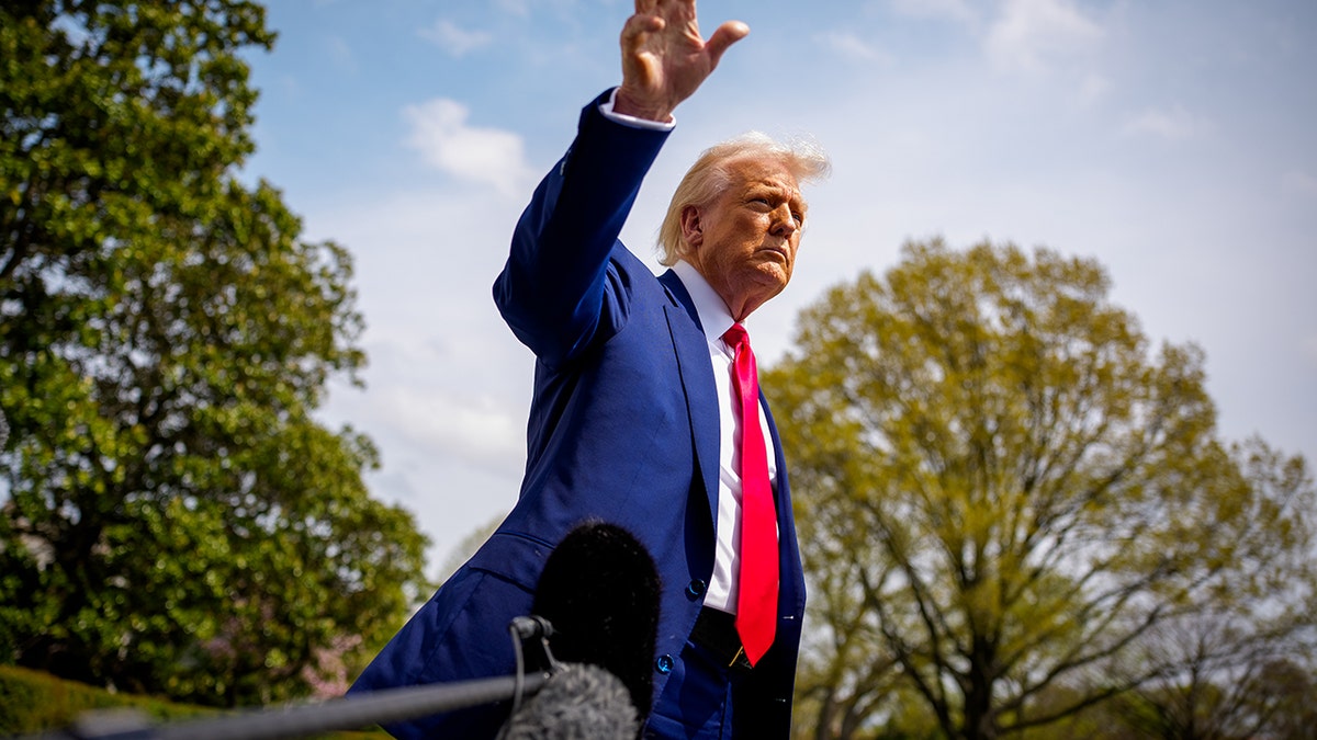 Donald Trump waves at reporters