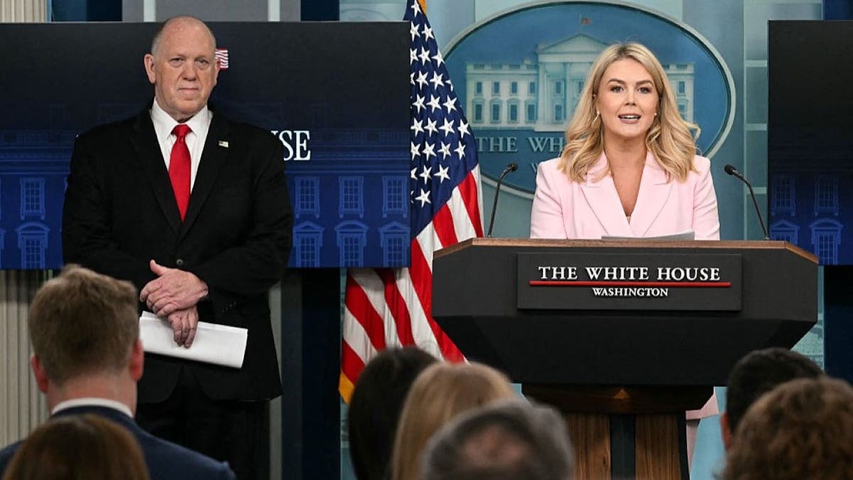 Leavitt with Tom Homan at press briefing room lectern
