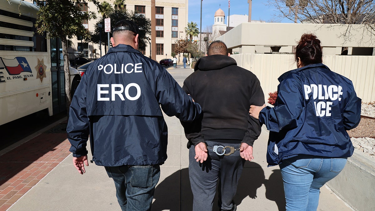 ICE ERO agents walk arrestee who is handcuffed