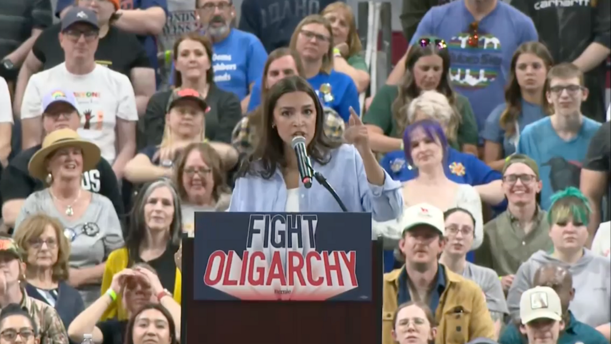 AOC speaking with a "fight oligarcy" sign on lectern