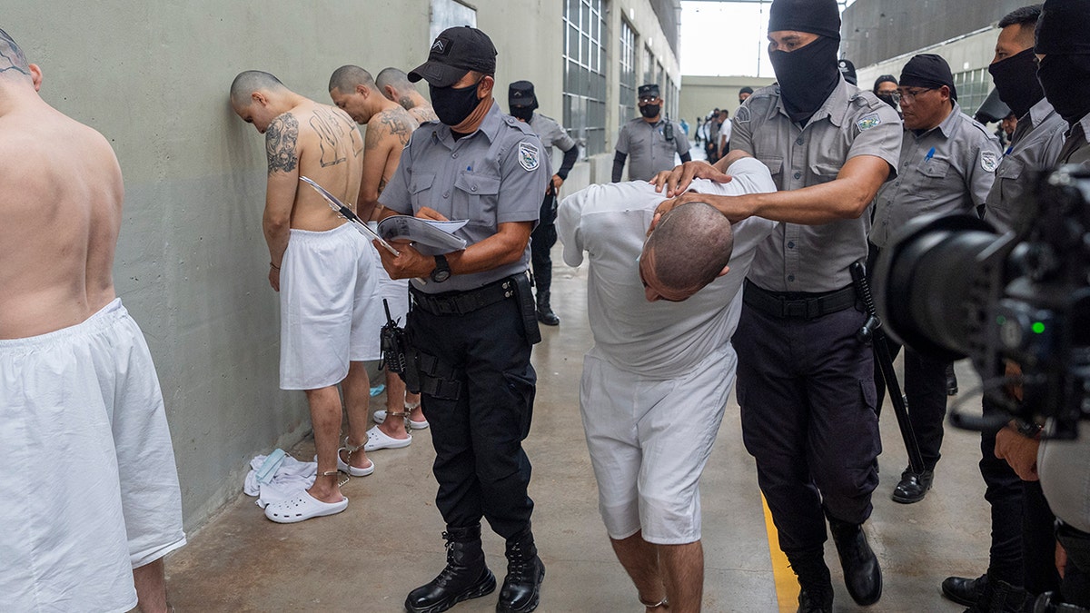Guards moving a prisoner at the notorious El Salvador prison