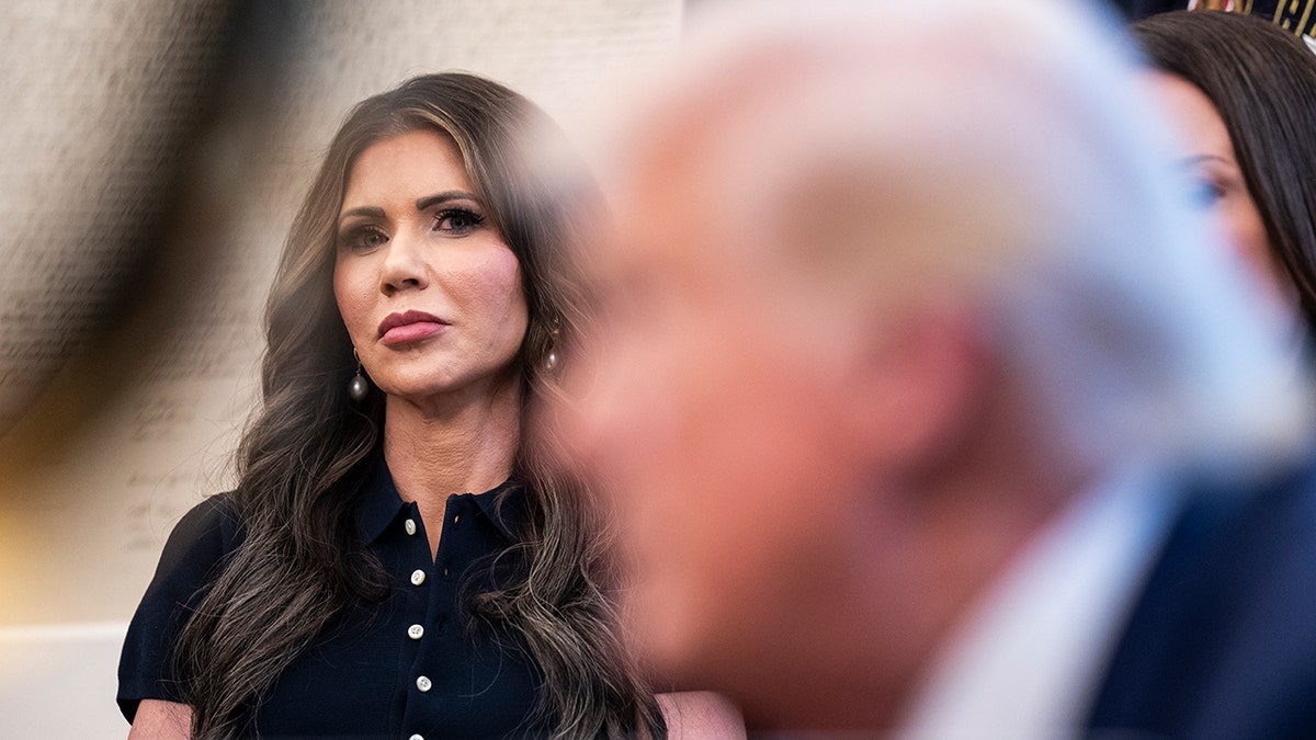 Homeland Security Secretary Kristi Noem listens as President Donald J Trump speaks