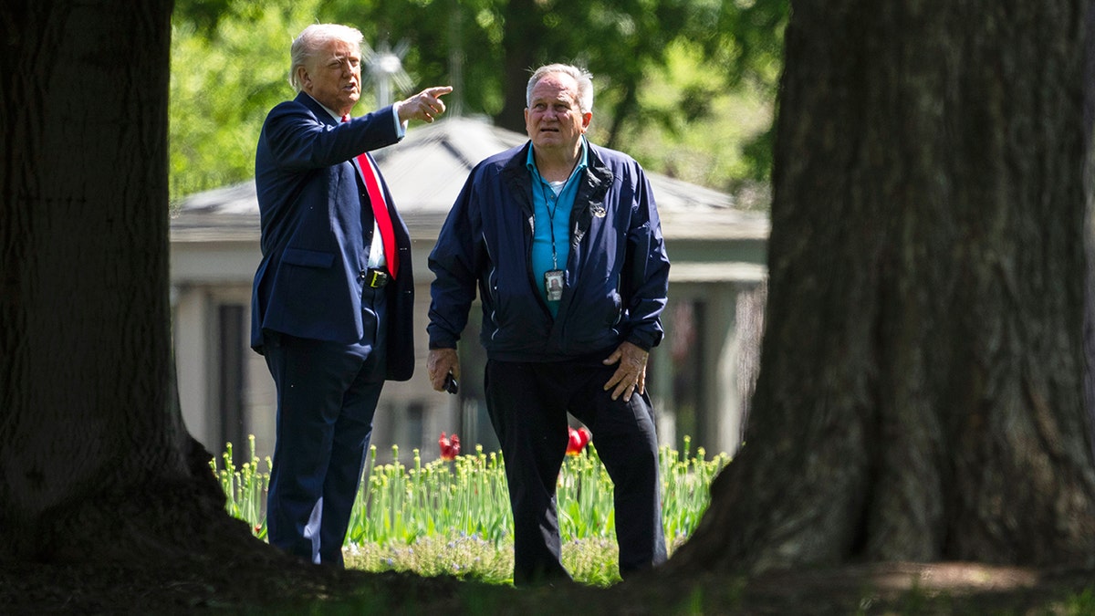 Trump pointing with White House groundskeeper by side