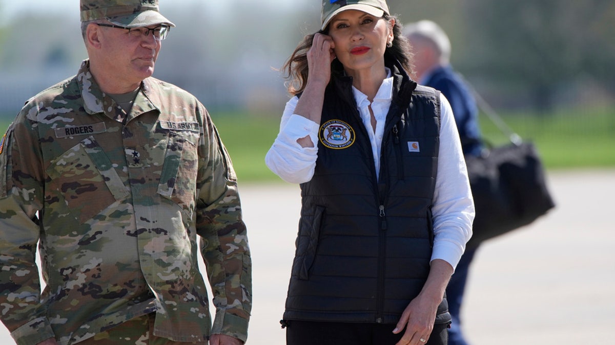 Michigan Gov. Gretchen Whitmer waits with Michigan National Guard adjutant general Major Gen. Paul Rogers at Selfridge Air National Guard Base, Tuesday, in Harrison Township, Mich.