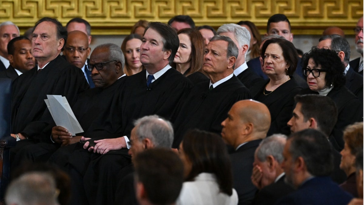 Supreme Court justices sit together in the audience during a formal event at the U.S. Capitol. Chief Justice John Roberts, Justices Brett Kavanaugh, Clarence Thomas, Samuel Alito, Amy Coney Barrett, Elena Kagan, and Sonia Sotomayor are visible in the front row, wearing black robes and facing forward.