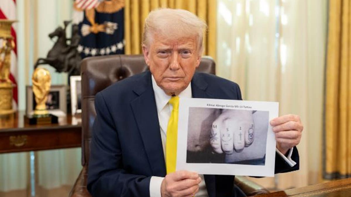 Trump holding a photo showing Garcia's hands with tattoos