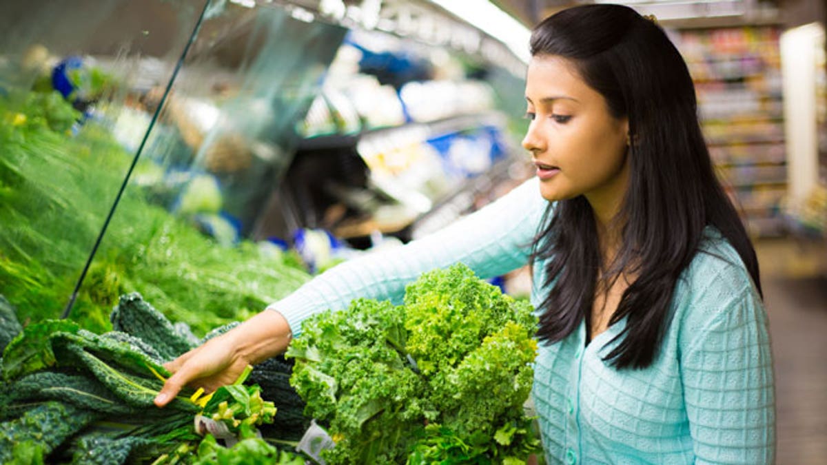 woman in produce section with lettuce