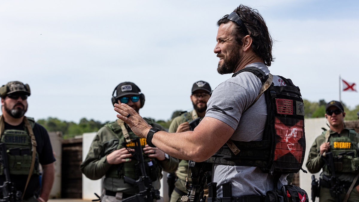 Jared Hudson on tarmac with camouflage wearing law enforcement