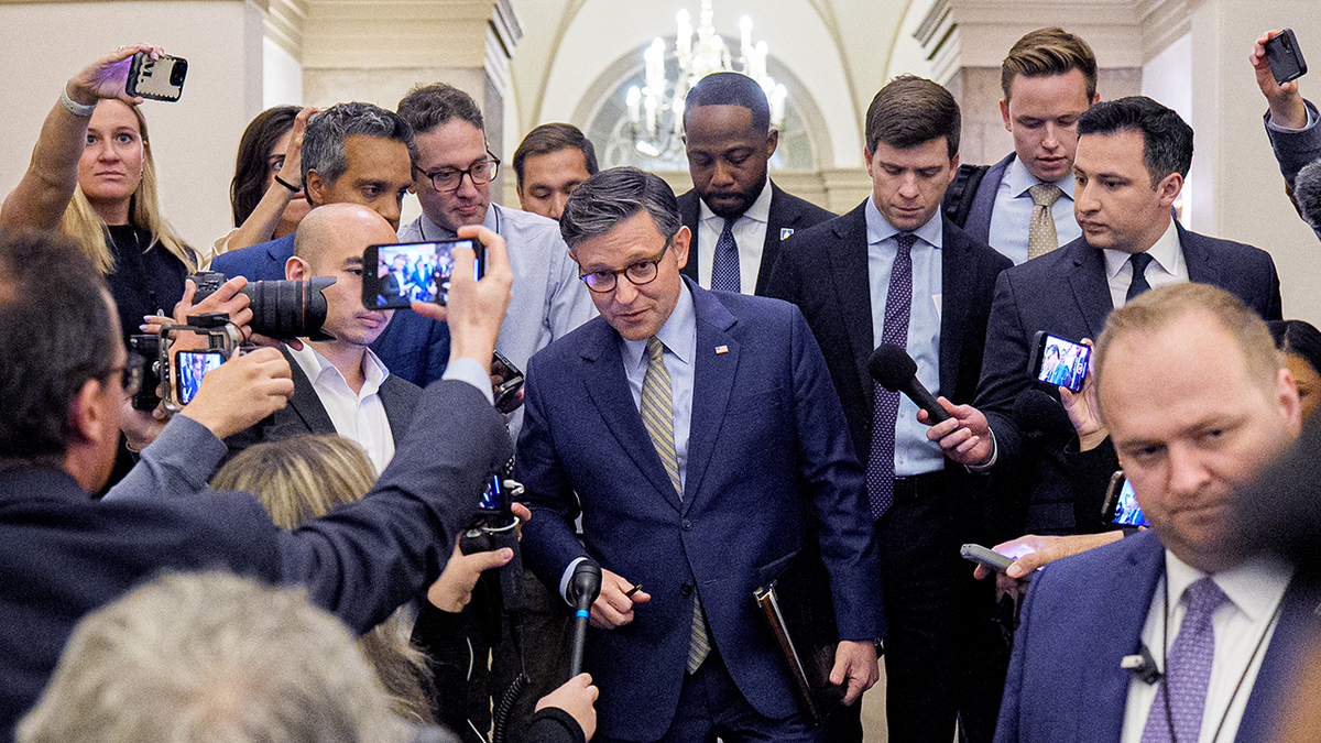 Speaker Johnson amid a gaggle of reporters