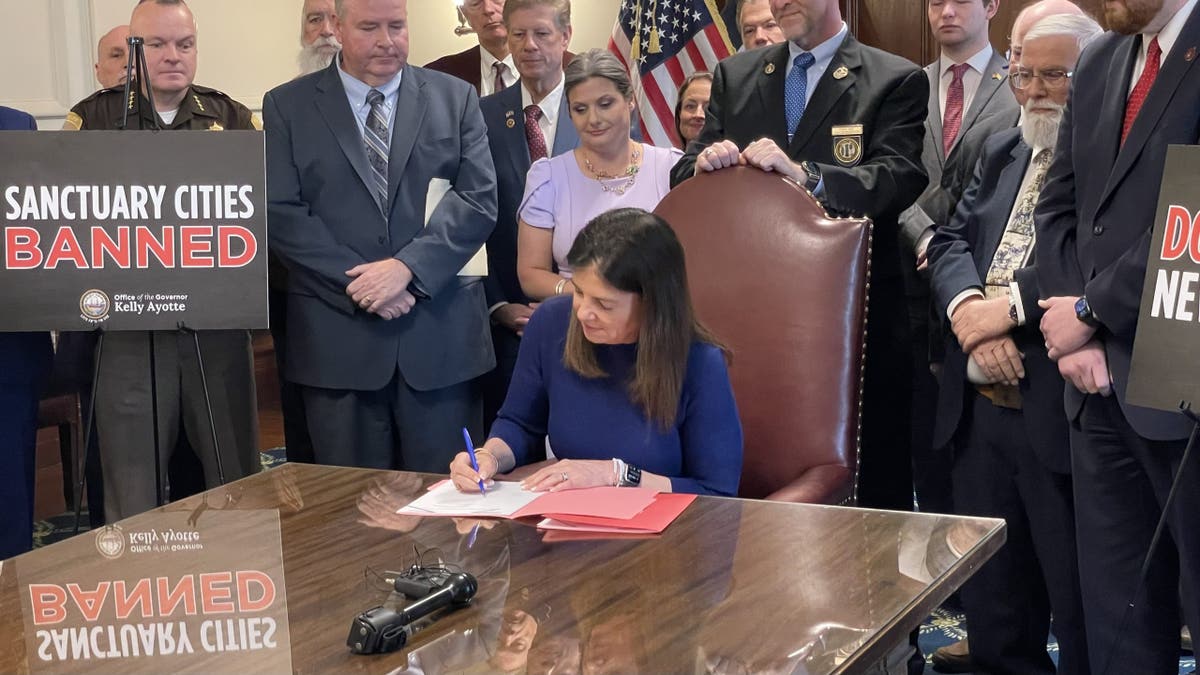 Republican Gov. Kelly Ayotte of New Hampshire signs into law two bills that ban sanctuary cities at the Statehouse in Concord, N.H., on Thursday.
