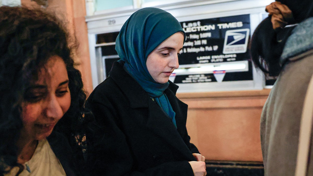 Mahmoud Khalil's wife Noor Abdalla. She is wearing all black with a turquoise scarf over her head.