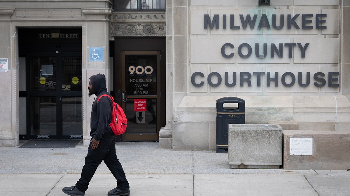 Pedestrian walks outside Milwaukee County Courthouse, site of federal judge's arrest.