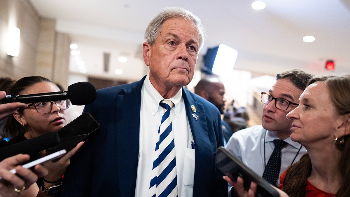 Norman surrounded by reporters gaggle 
