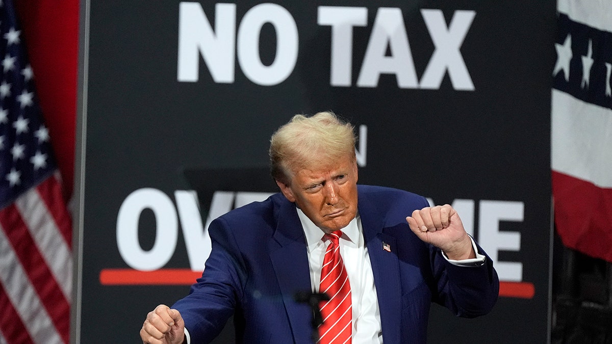 Trump dances at a rally in front of a no tax on overtime sign