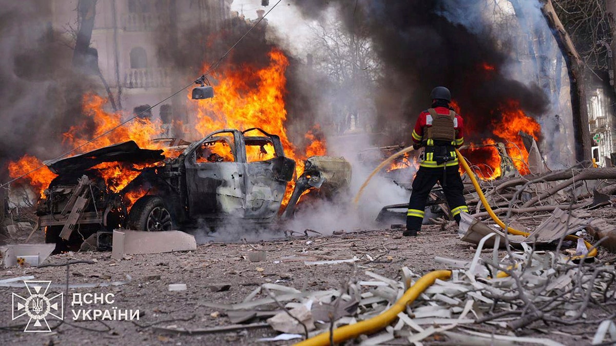 firefighters put out a vehicle fire amid rubble in Sumy, Ukraine
