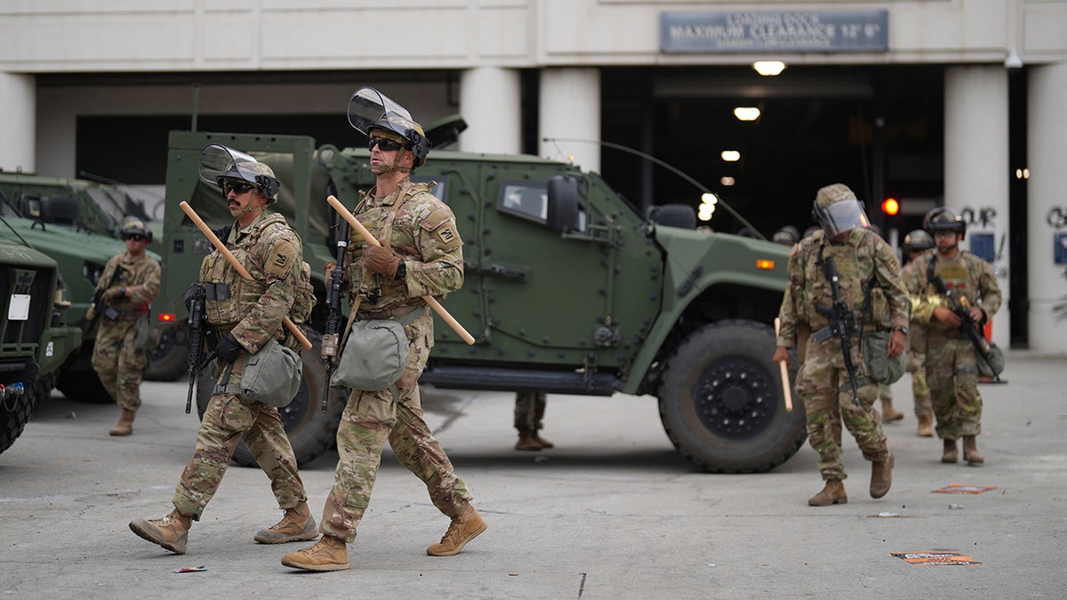 U.S. National Guard troops walking by vehicle
