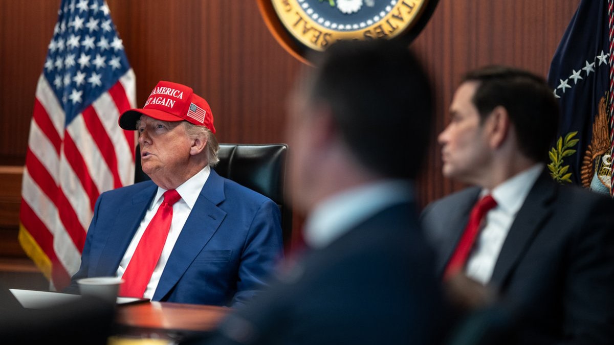 President Donald Trump wearing a MAGA hat in The Situation Room