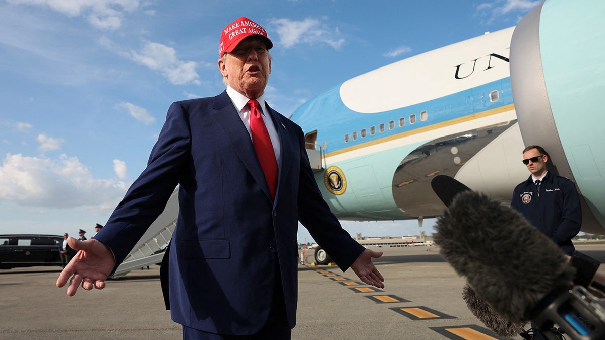 Trump on tarmac, Air Force One behind him