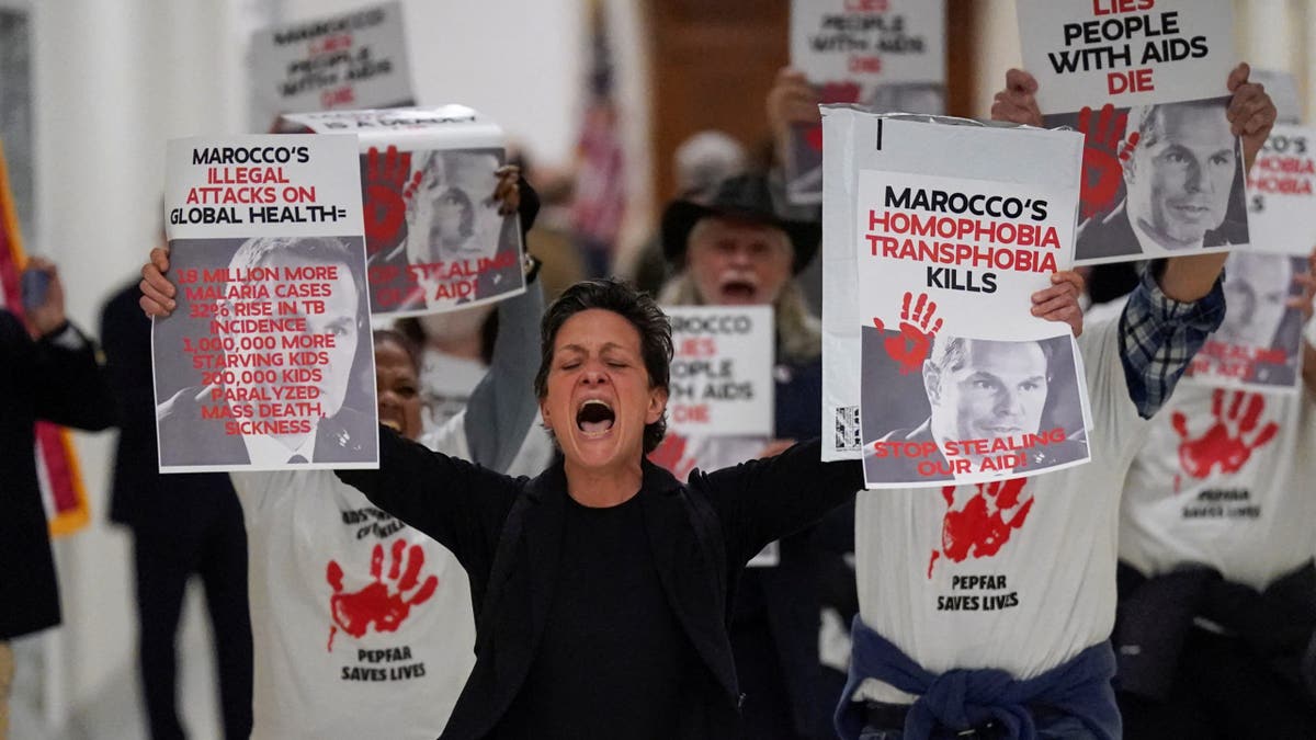 Protesters hold placards as Pete Marocco, deputy administrator-designate at the U.S. Agency for International Development (USAID), attends a meeting with members of Congress to discuss foreign assistance, on Capitol Hill in Washington, D.C., U.S. March 5, 2025. REUTERS/Kent Nishimura