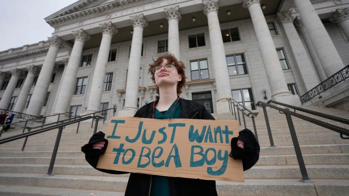 Trans activist with sign outside state capitol