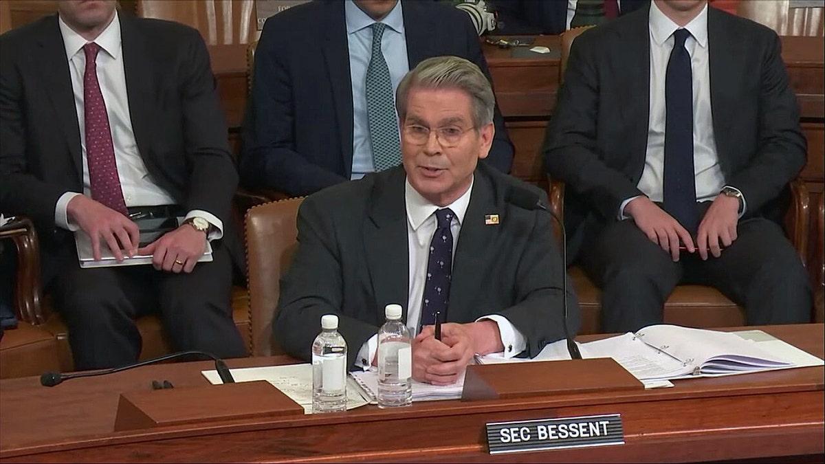 Treasury Secretary Scott Bessent speaking at a congressional hearing, seated behind a nameplate