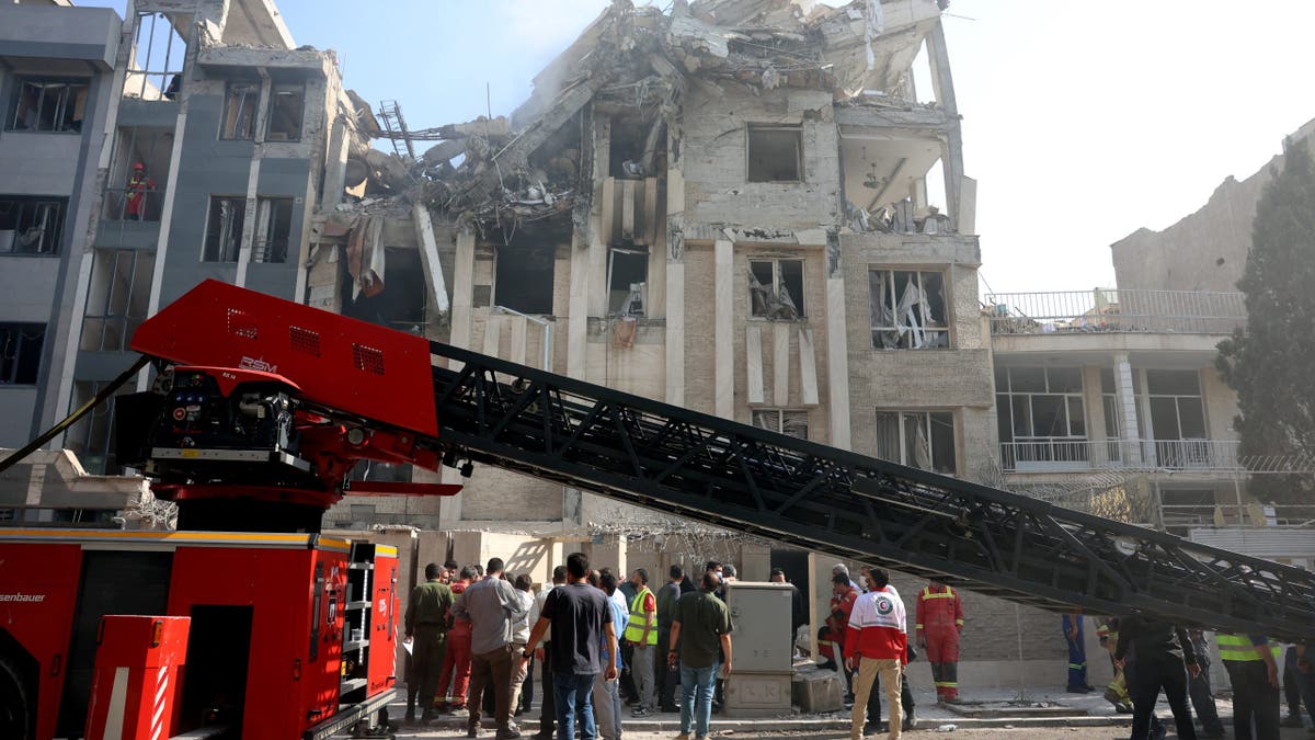 Rescue teams work outside a heavily damaged building, targeted by an Israeli strike in the Iranian capital Tehran on June 13, 2025. 
