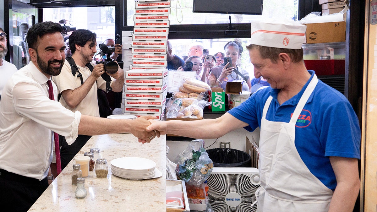Zohran Mamdani shaking hands with fast-food worker