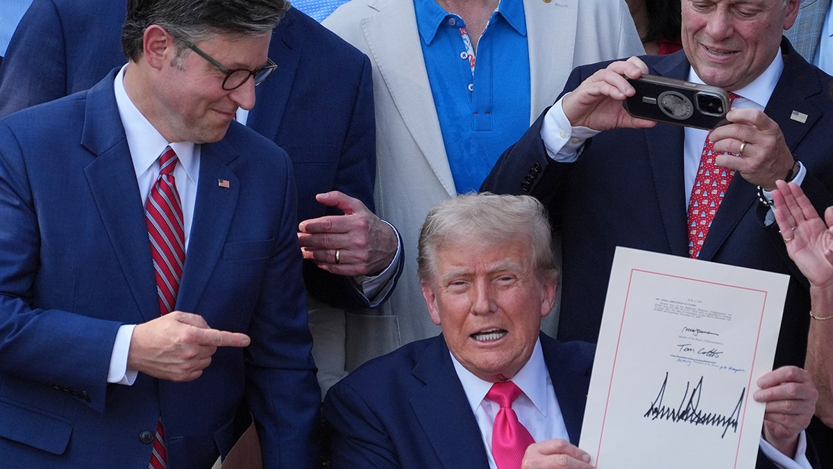 Trump holds up signed big, beautiful bill at White House