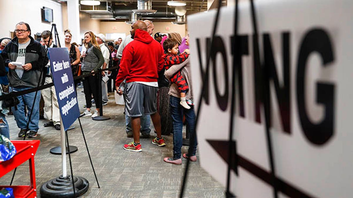 A line of early voters wait in queue at the Franklin County Board of Elections, Monday, Nov. 7, 2016, in Columbus, Ohio. Heavy turnout has caused long lines as voters take advantage of their last opportunity to vote before election day. (AP Photo/John Minchillo)