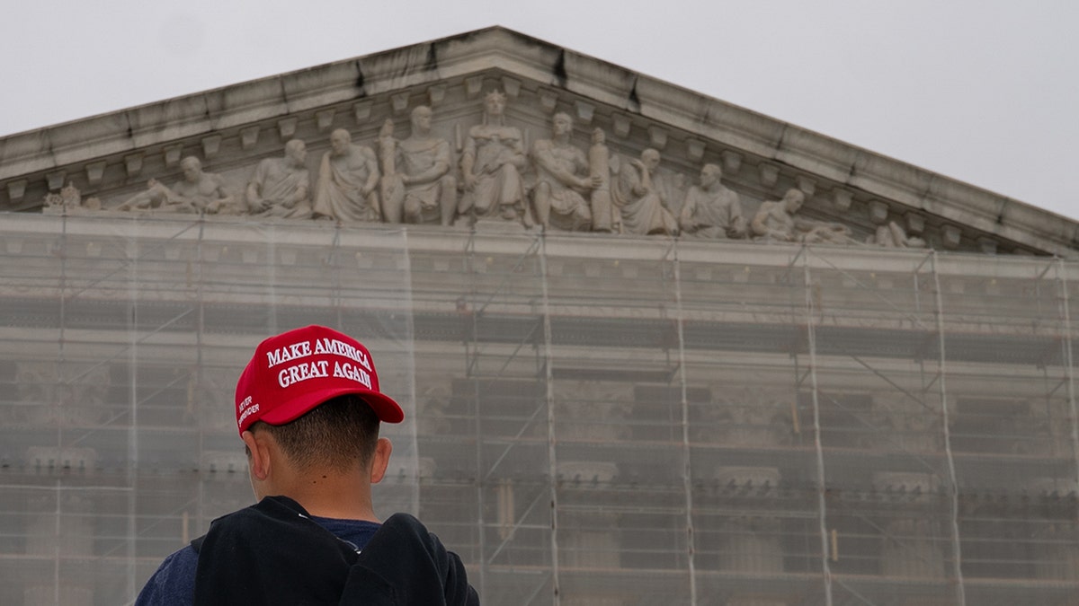 MAGA hat worn backwards before facade of the Supreme Court