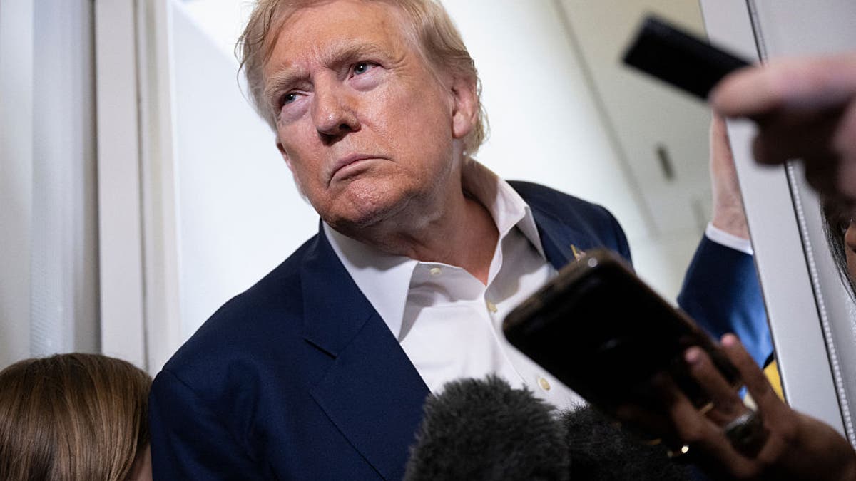 President Donald Trump listens to questions from reporters aboard Air Force One over the United Kingdom on July 29, 2025 as he returns to Washington following a trip to Scotland.