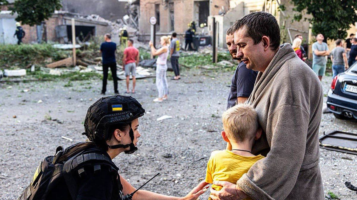 Ukrainians outside building hit by Russian attack