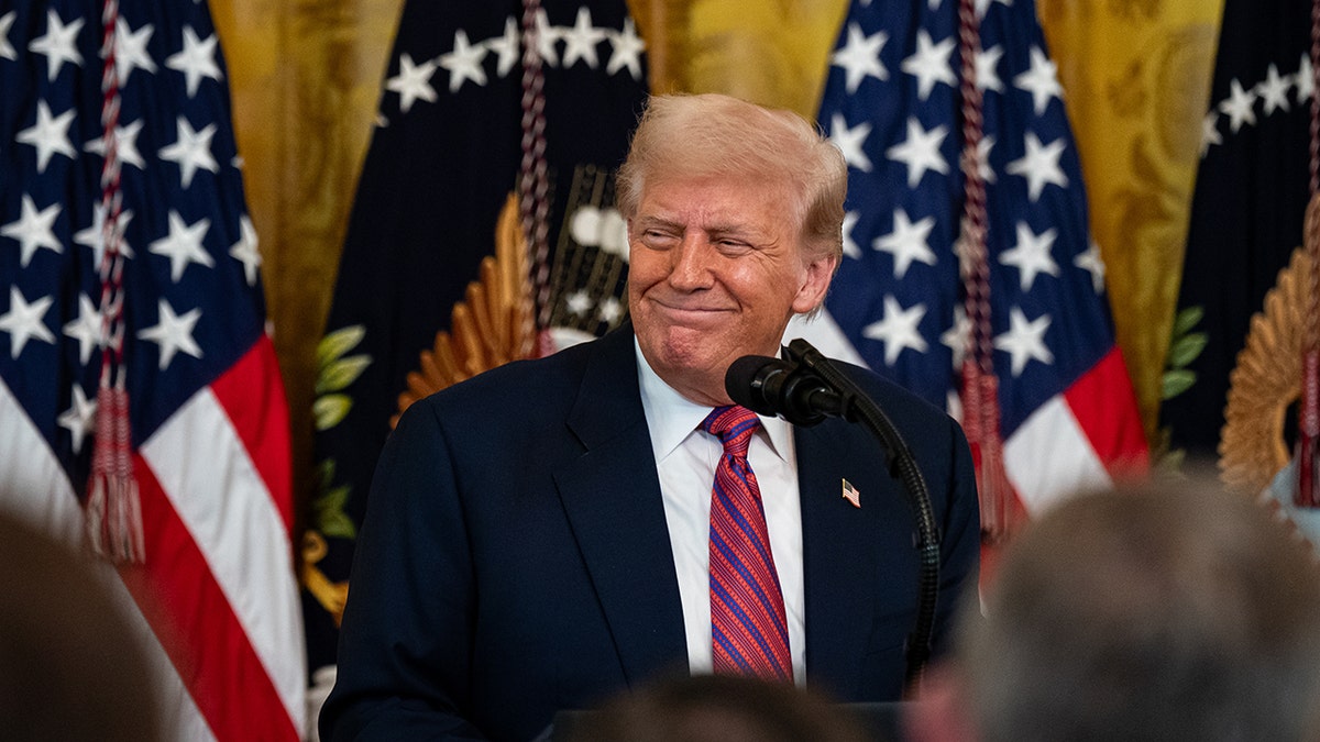 Trump grins during a signing ceremony for the GENIUS Act