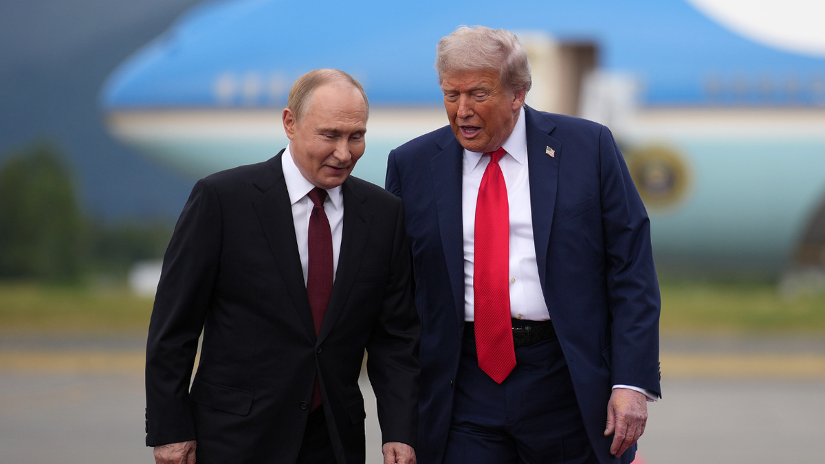 U.S. President Donald Trump walks next to Russian President Vladimir Putin in Alaska