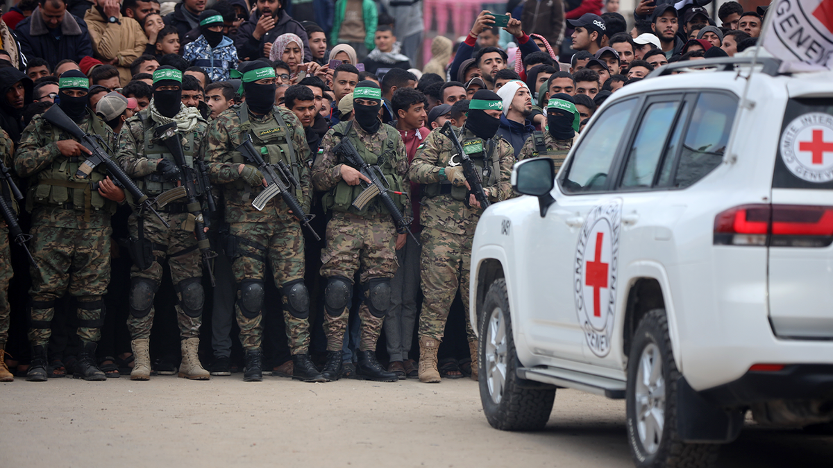 hamas fighters in gaza in front of red cross vehicle
