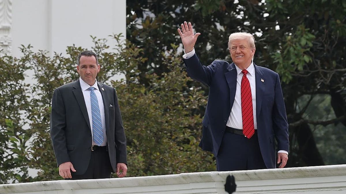 U.S. President Donald Trump gestures from the roof of the West Wing of the White House as he takes a tour on August 05, 2025 in Washington, DC.