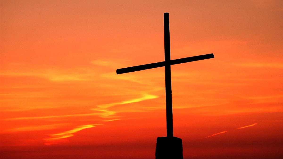 Cross against an orange-colored sky