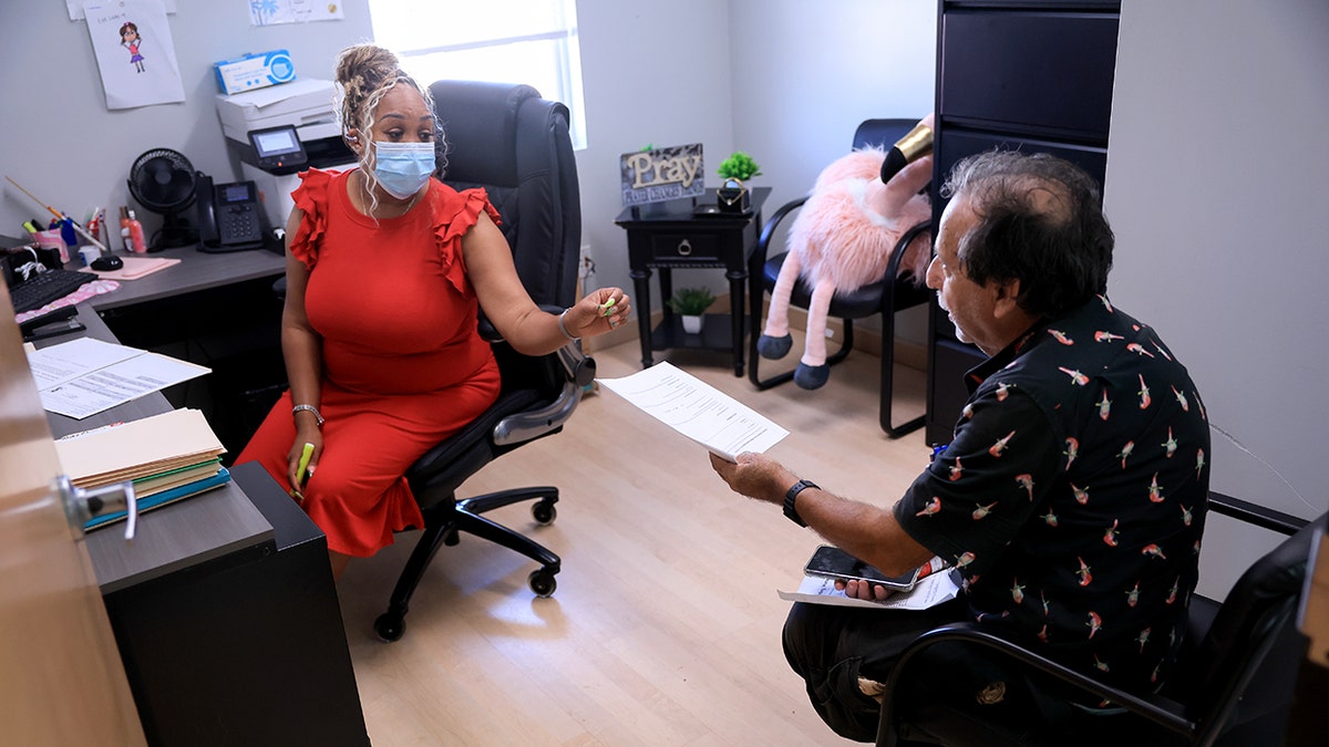 Alicia Lester, case manager and Service Coordinator, helps Henry Pedoff fill out a Medicaid and a food stamps application at the LifeNet4Families center on May 14, 2025 in Lauderhill, Florida. 