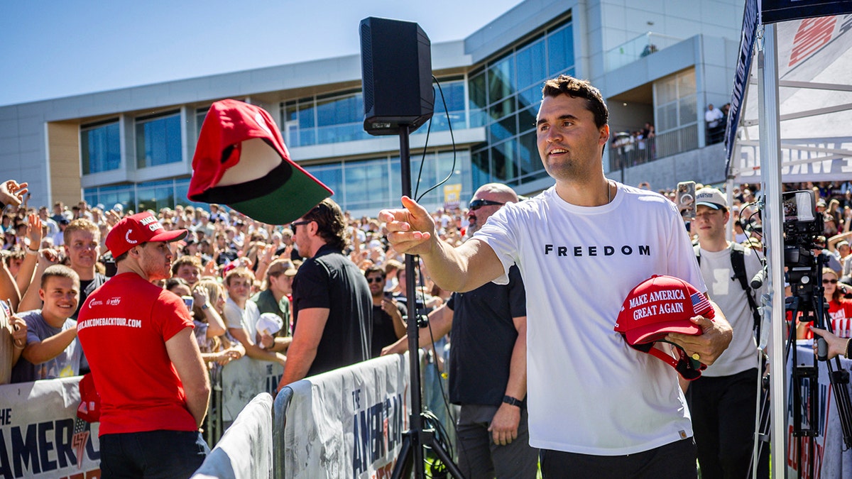 Charlie Kirk before he was shot hands out hats to the crowd