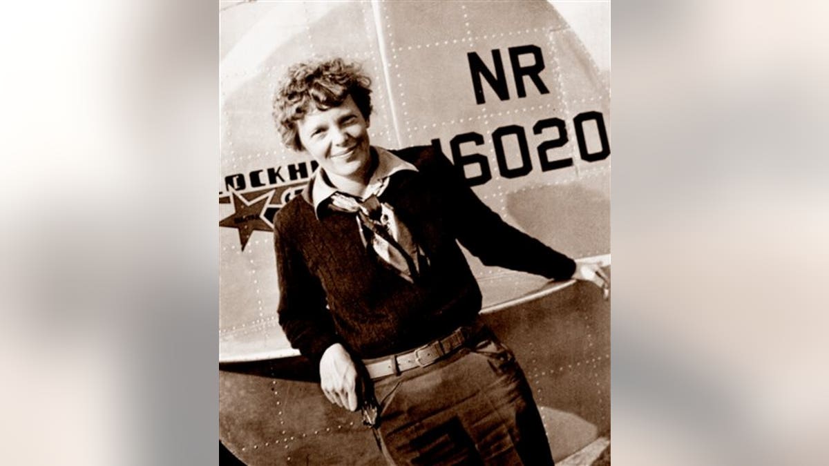 This May 20, 1937 photo, provided by The Paragon Agency, shows aviator Amelia Earhart at the tail of her Electra plane, taken at Burbank Airport in Burbank, Calif. (Albert Bresnik/The Paragon Agency via AP)