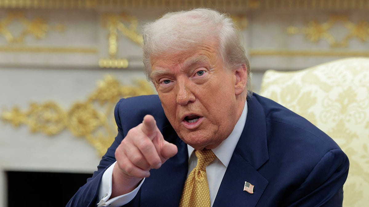 President Donald Trump pointing inside the White House.