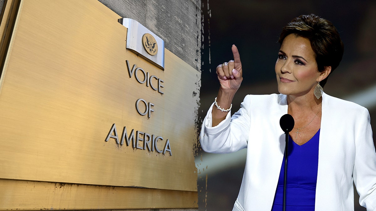 Kari Lake speaking at a podium next to the Voice of America building sign.