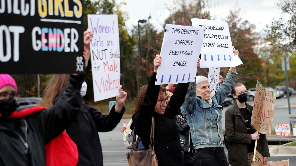 Photo shows people protesting in Loudoun County Virginia against school policies and holding signs in 2021