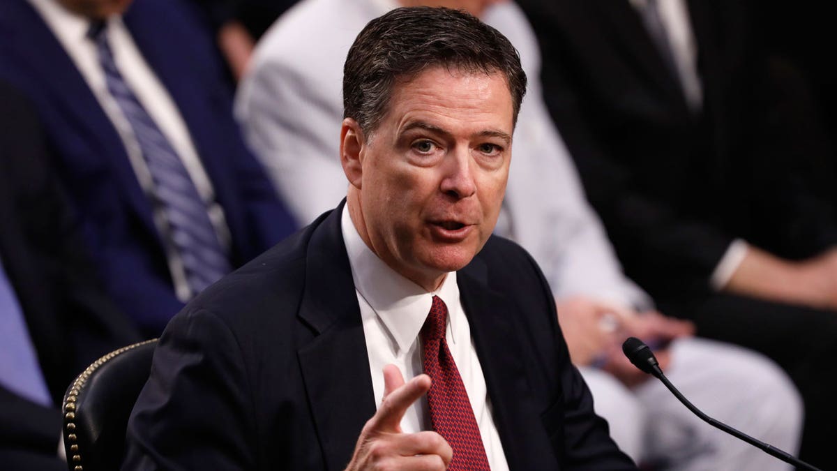 James Comey wears red tie and black suit