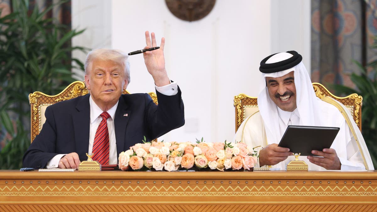 President Donald Trump waves to media alongside Emir of Qatar al-Thani 